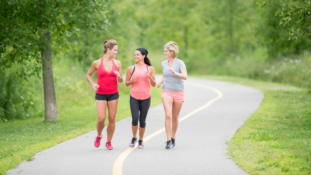 A group of friends laugh as they jog and enjoy fun outdoor activities.
